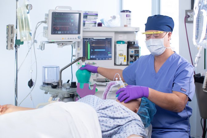 Certified Registered Nurse Anesthetist preparing anesthesia equipment in a clinical setting
