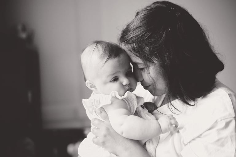 portrait en noir et blanc d’une maman tenant son bébé, moment doux et intime