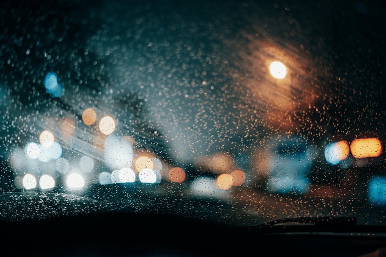 Road and City Lights blurred through a rainy windshield Photo by Ugur Tandogan (Pexels.com)