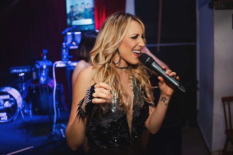 Singer Keka singing with a microphone in hand.
