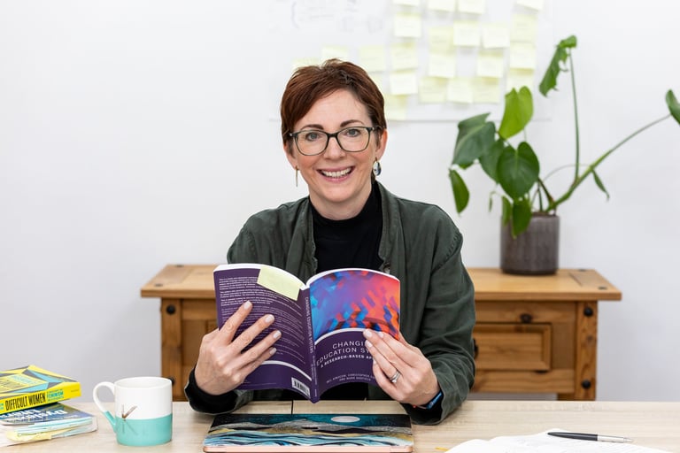 a woman is smiling and holding a book