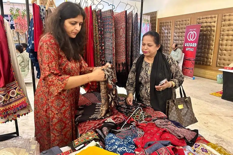 a woman standing in front of a table with a bunch of clothes