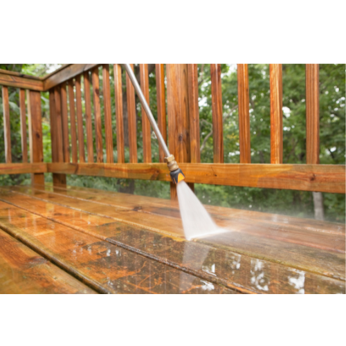 Power washing a wooden deck to remove dirt and buildup during an exterior cleaning service 