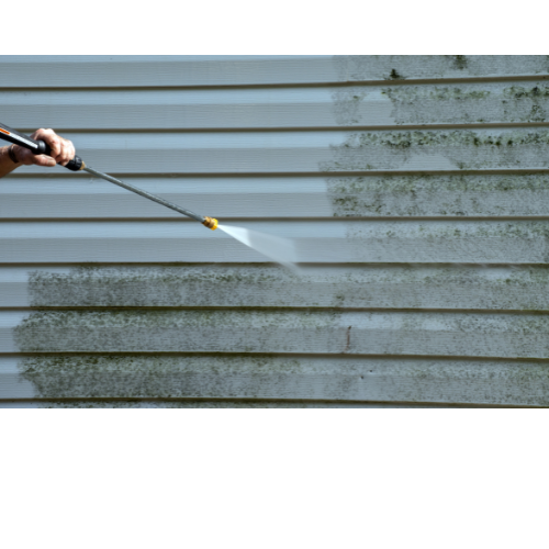 Power washing mold and dirt off vinyl house siding during a residential exterior cleaning service 