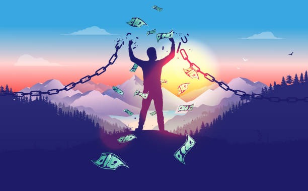 Person standing on a mountain at sunset breaking a chain link, symbolizing financial freedom