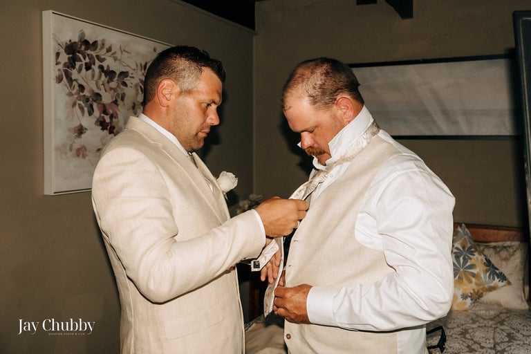Groom getting ready with groomsman adjusting tie Avalon Castle Melbourne wedding morning