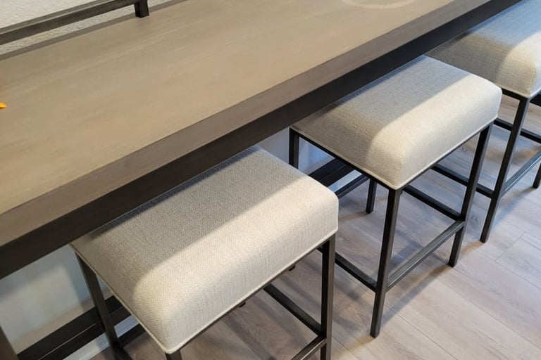 Modern wooden console table with three upholstered stools tucked underneath for space-saving seating.