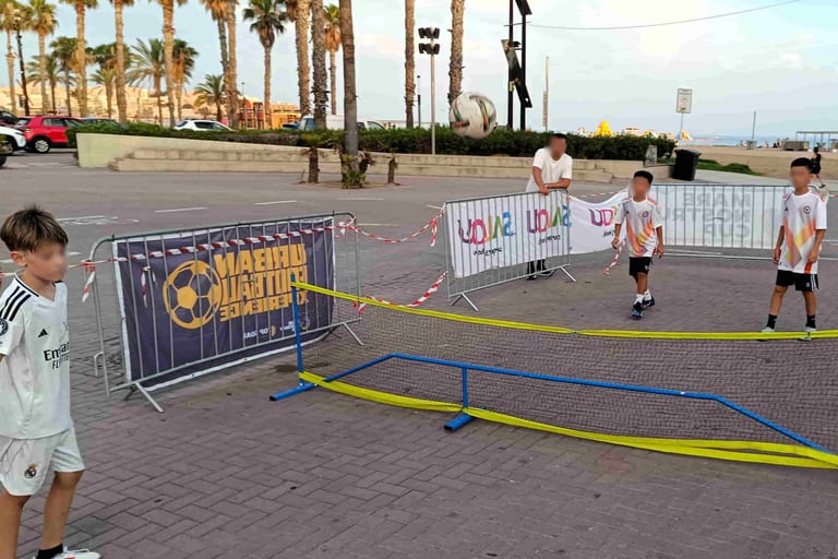 Niños jugando a fútbol tenis durante una animación de fútbol
