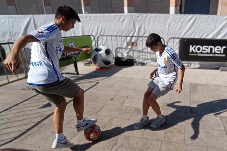 Participantes realizando retos de freestyle fútbol con el público durante un evento