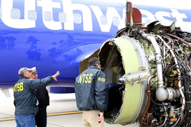 NTSB investigators examine a damaged Southwest Airlines jet engine after a failure.