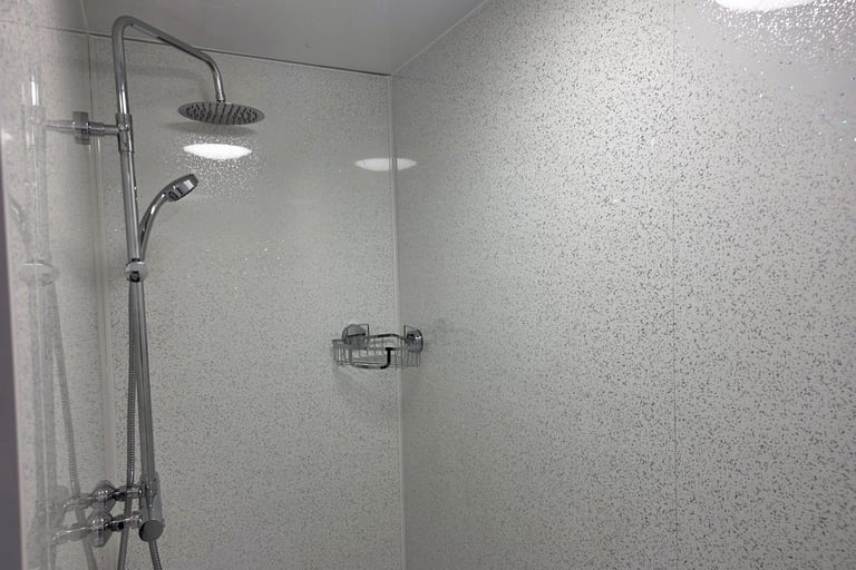 Shower area inside a temporary bathroom pod supplied during insurance claims and renovation projects.