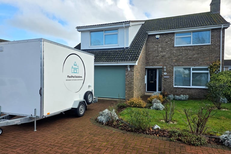 Temporary bathroom pod installed on a residential driveway during a home renovation.