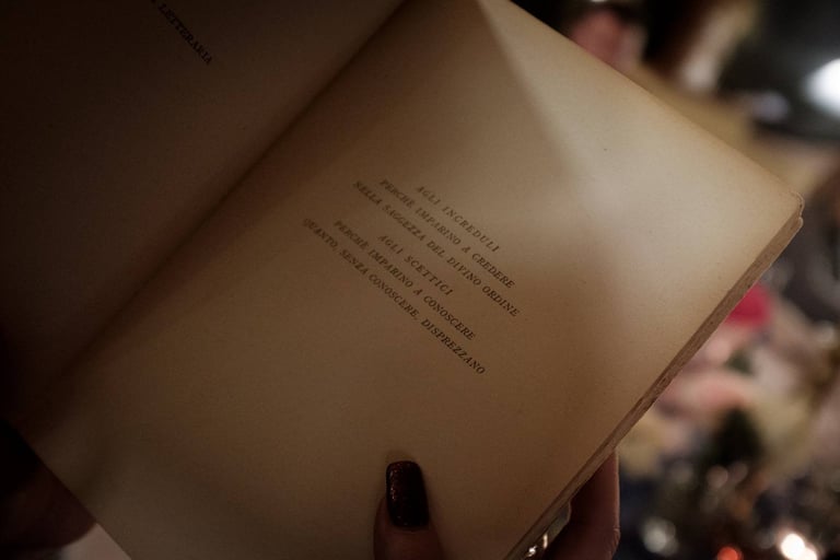 Libro aperto su pagina con scritto: "Agli increduli, perchè imparino a credere"