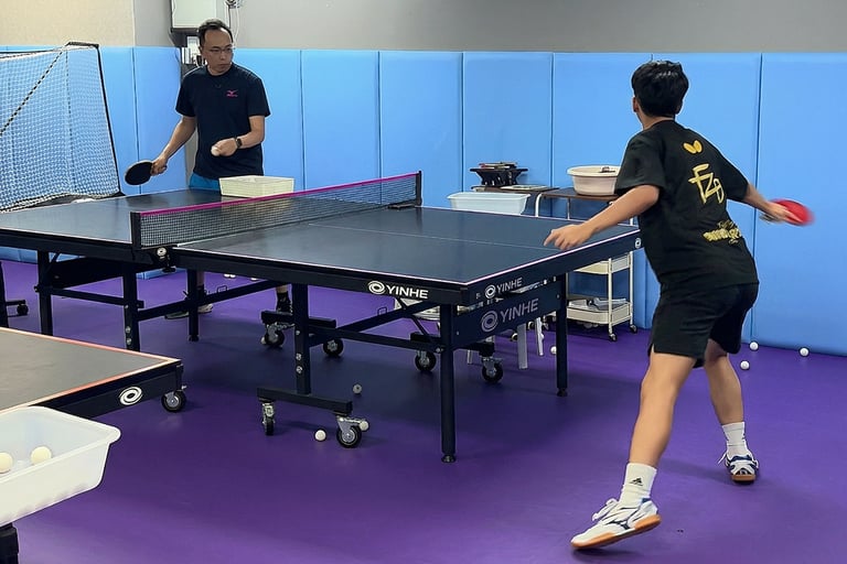 Advanced table tennis rally training with coach focusing on speed, footwork, and tactics