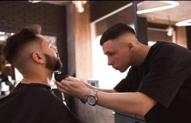 Professional barber providing a modern haircut service at Alpha Studio in Vilnius