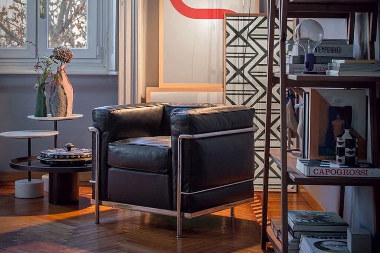 Modern leather armchair beside bookshelves and soft window light, showing a calm and practical livin