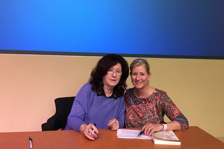 Dr. Sue Johnson and Dr. Bernis Riley sitting at a desk.