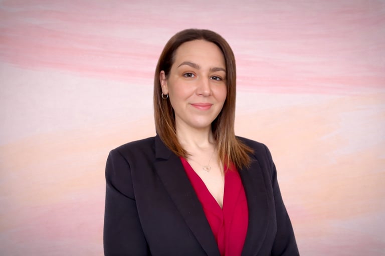 Approachable bookkeeping professional in business attire, smiling confidently against a soft pastel