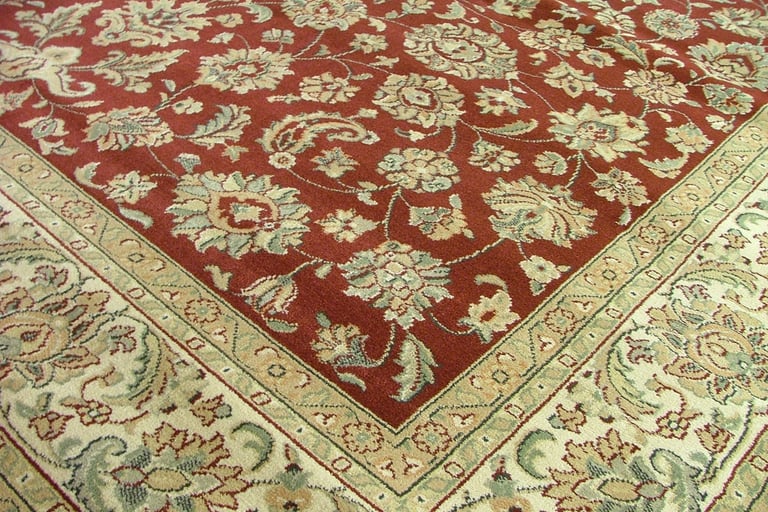 Close-up of a traditional Persian-style area rug featuring intricate floral and paisley patterns in 
