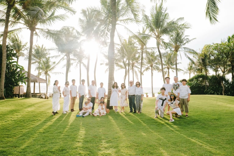 Extended family group session on the lawn at The Legian Seminyak Bali during golden hour.
