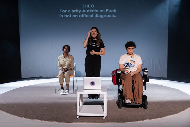 Three figures on a stage, Evlyne seated, Anna stood, and Theo seated