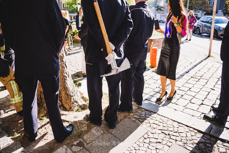 A fireman holding an axe photographed from behind. 