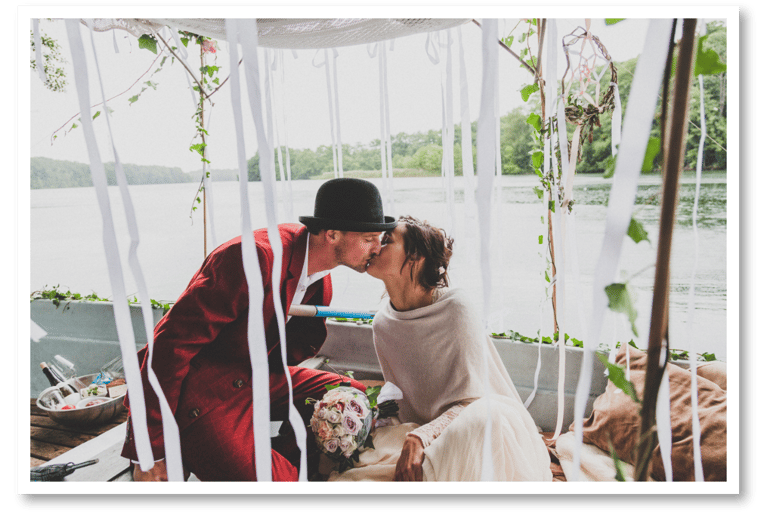 Husband and wife kissing on a boat.