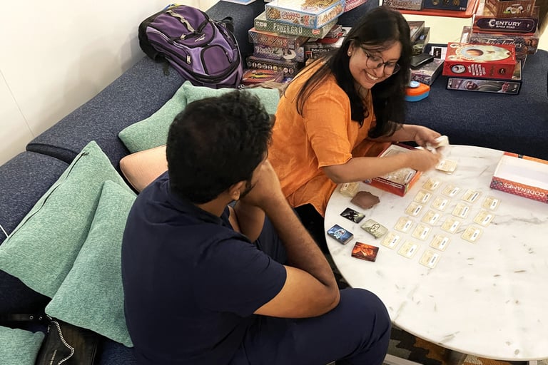 A happy Mansi setting up and demonstrating the game Codenames.