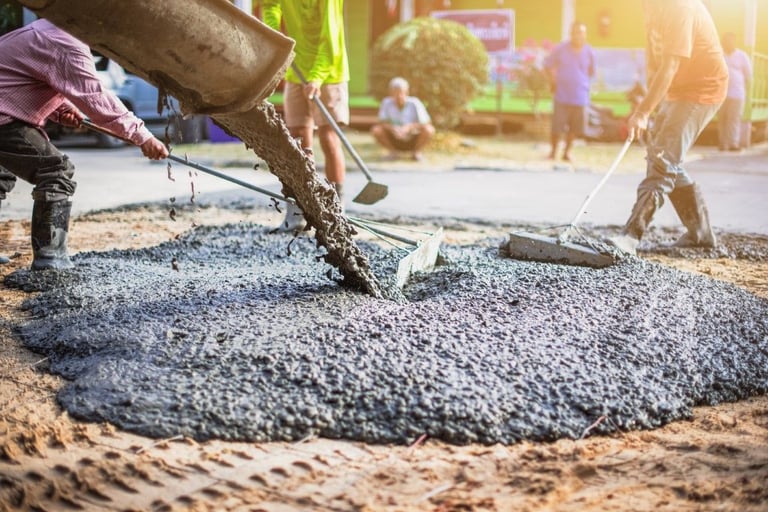 construction workers are pouring concrete mix