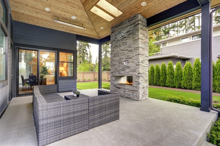 a concrete patio with a couch and a fireplace