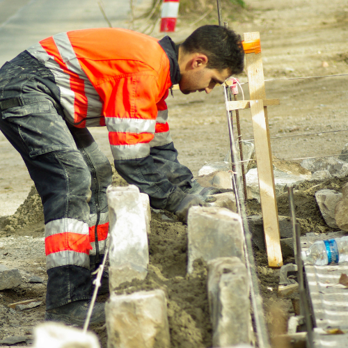 a man in a safety vest is working on a construction site