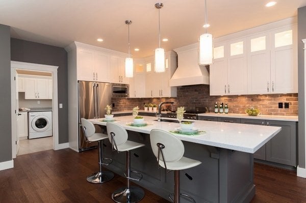 Cozinha com piso imitando madeira, com forro de gesso,, iluminação embutida e pendentes.