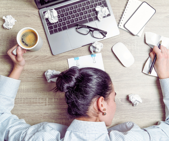 a woman sitting at a desk with a cup of coffee