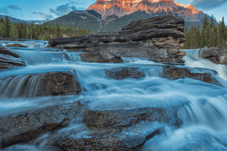 a mountain stream running through a valley with a mountain in the background