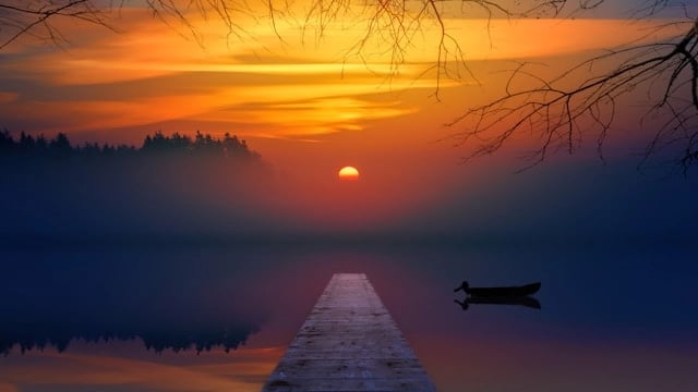 Coucher de soleil sur un lac avec une barque et une avancée en bois