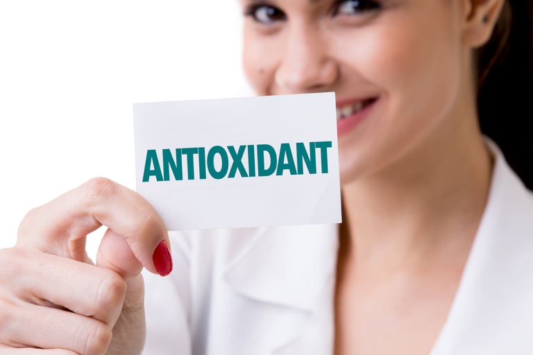 A smiling healthcare professional holding a card with the word ANTIOXIDANT in green text.