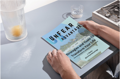 a person holding a book in front of a table