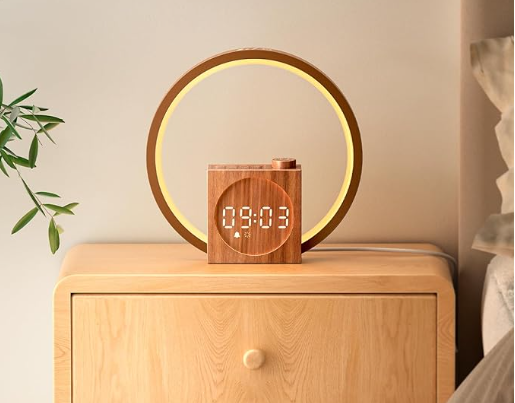 Dreamegg Sunrise alarm clock with wood-grain finish and warm glowing light on a bedside table.