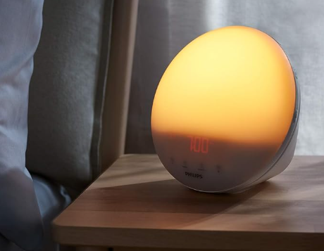 Philips SmartSleep HF3520 wake-up light showing a vibrant orange and yellow sunrise simulation