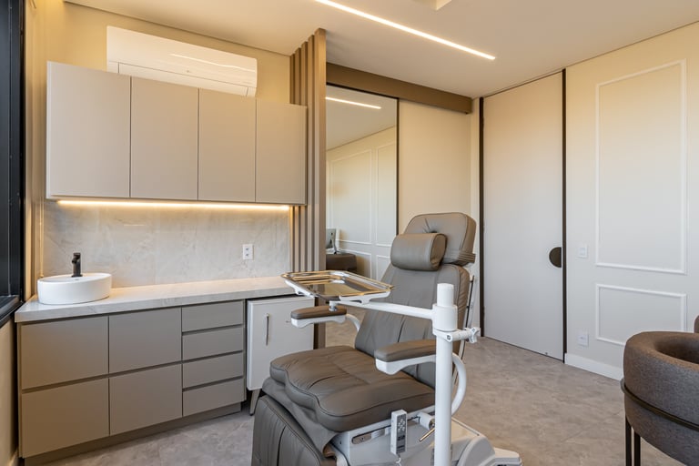 Consultório médico com marcenaria sob medida: armário inferior e superior, mini geladeira e bancada.