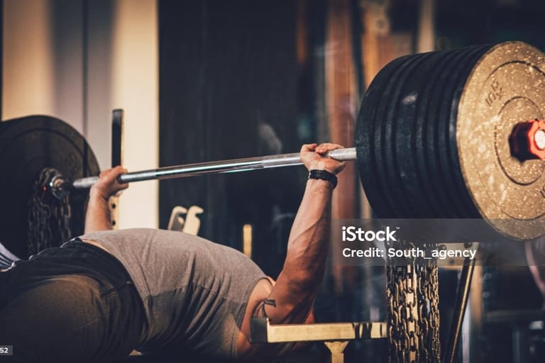 a man doing a barbell bench press in a gym
