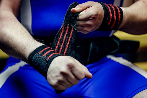 a man in a blue shirt is holding a wristband