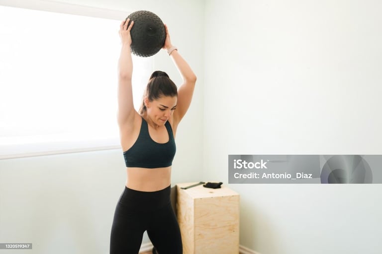 a woman holding a medicine ball in her hands