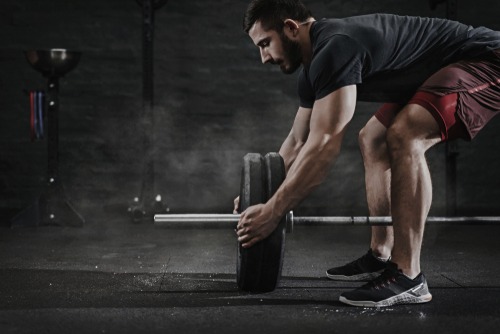a man is doing a barbell exercise