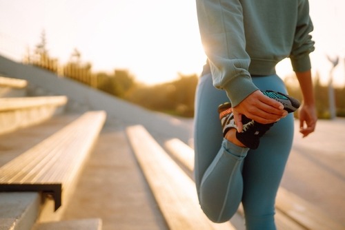 a woman in blue leggings stretching