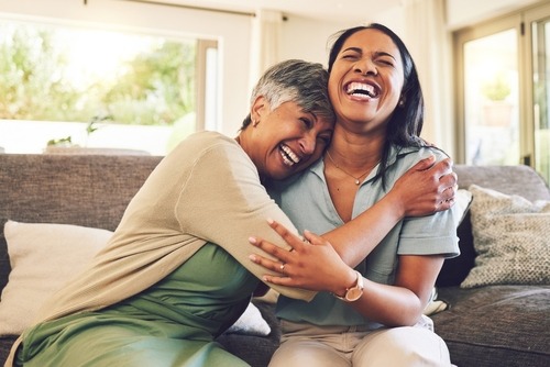 a woman and a woman are smiling and hugging