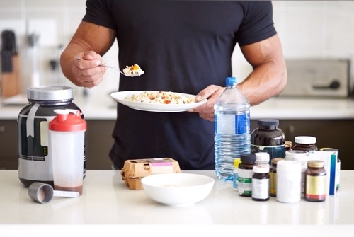 a man holding a plate with food and a fork