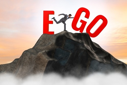 a man standing on top of a mountain with a large letter e on it
