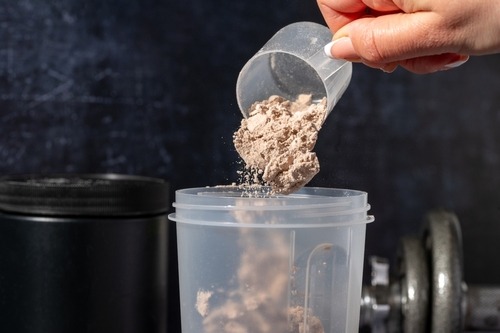 protein powder being poured into a cup