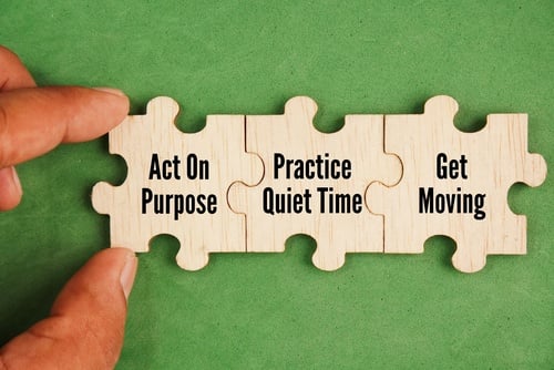 Hand assembling wooden puzzle pieces with motivational tips for mental wellness and productivity.